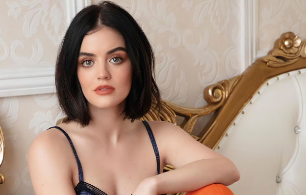 Красивая девушка, актриса Люси Хейл сидит на диване