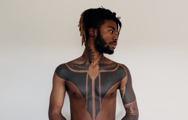 Темнокожий мужчина с татуировками на теле