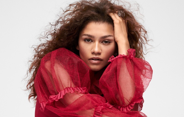 Кареглазая актриса Зендая в красном наряде с рукой в волосах