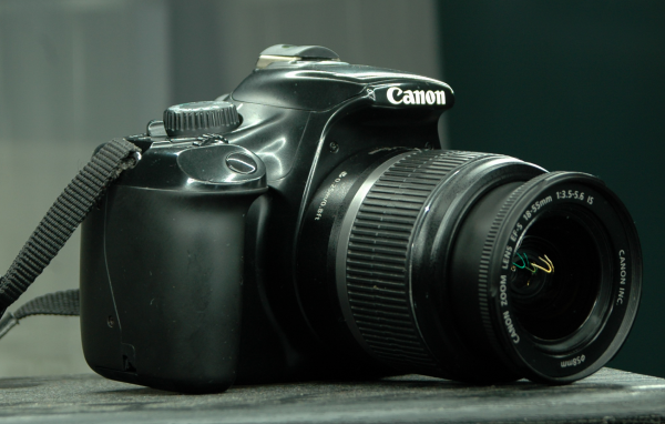 Фотоаппарат Canon 1100D лежит на столе