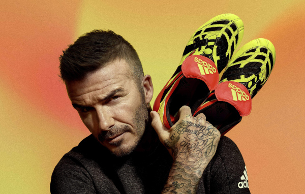 Футболист Дэвид Бекхэм с кедами Адидас в руке