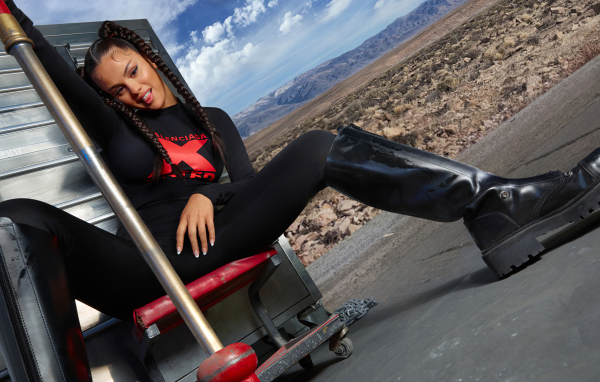 Смешная девушка, певица и актриса Селена Гомес сидит на стуле