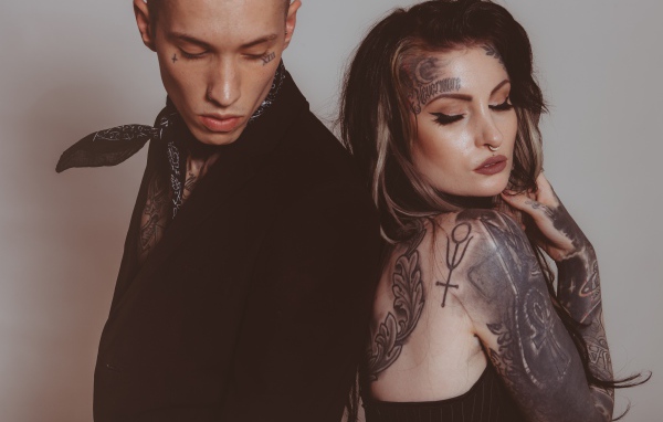 Девушка и парень с татуировками на теле на сером фоне