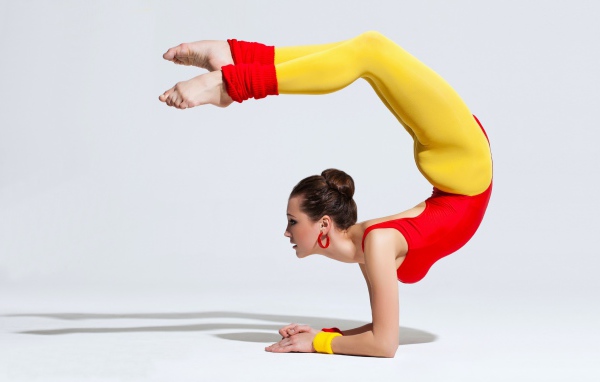 Девушка гимнастка делает стойку 