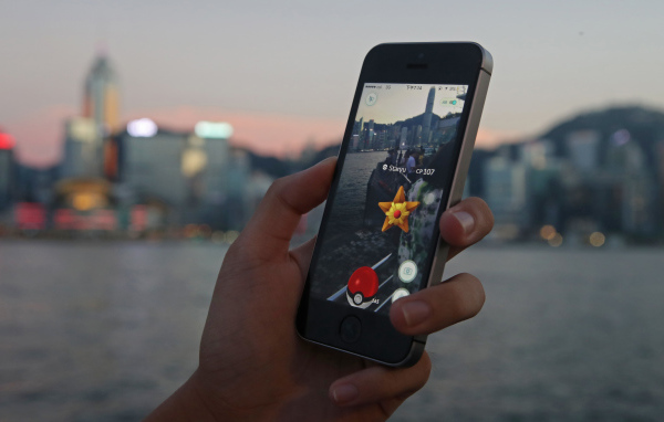 Парень ловит покемонов на смартфоне 