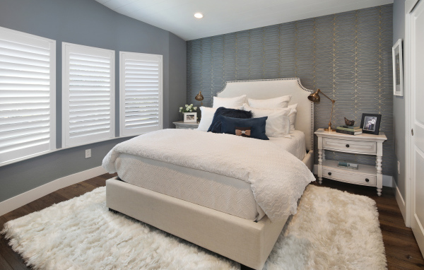 Высокая кровать в спальной комнате в серых тонах