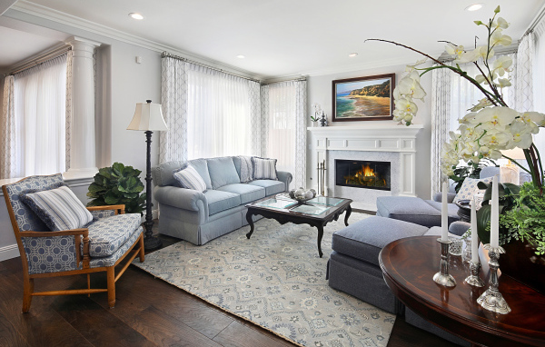 Большая гостиная комната с камином и живыми цветами