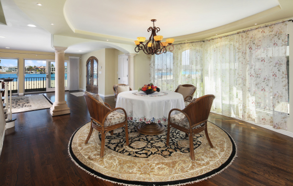 Большая гостиная комната с большими окнами и столом 