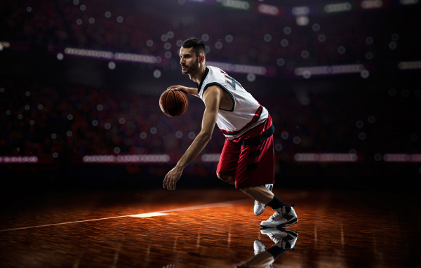 Мужчина баскетболист отбивает мяч на поле 