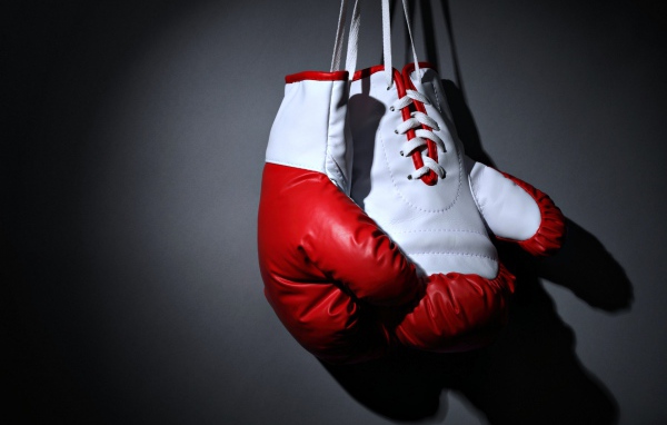 Красные боксерские перчатки на сером фоне