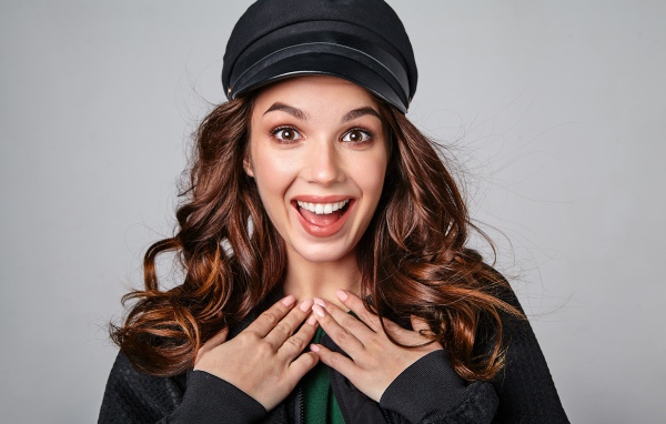 Удивленная кареглазая девушка в черной кепке