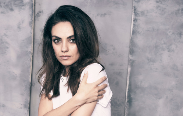 Нежная девушка, актриса Мила Кунис на сером фоне