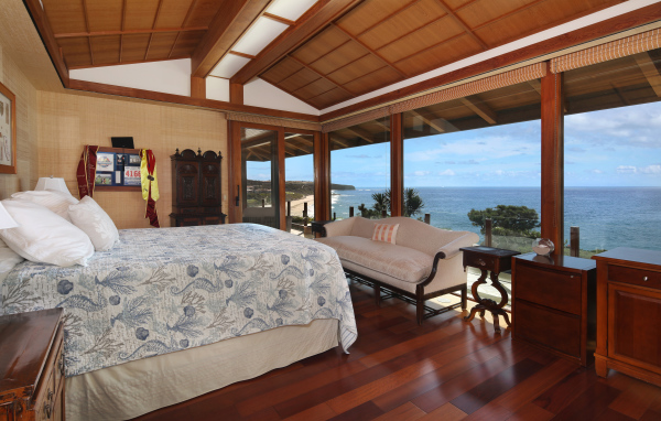 Деревянная спальня с большой кроватью и видом на море 