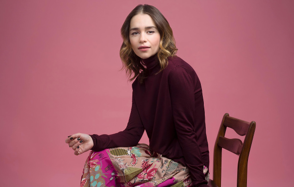 Молодая актриса Эмилия Кларк сидит на стуле