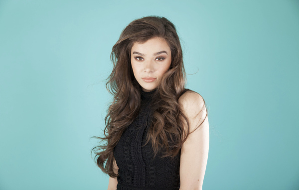 Молодая актриса Хейли Стейнфилд  в черном наряде на голубом фоне