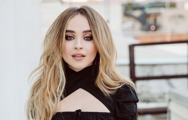 Молодая красивая блондинка, актриса и певица Сабрина Карпентер в черном наряде