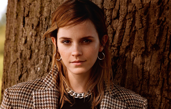 Молодая кареглазая девушка, актриса Эмма Уотсон у дерева