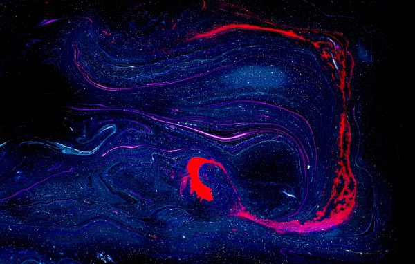 Blurry smudge of blue and red paint on black background