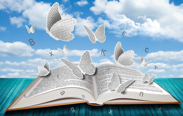 Бумажные бабочки и буквы над книгой 