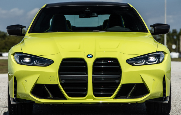 Желтый автомобиль  BMW M4 Coupé 2021 года вид спереди