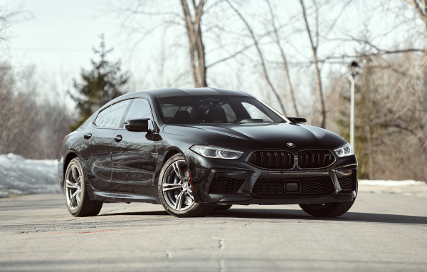 Черный автомобиль BMW M8 в лучах солнца