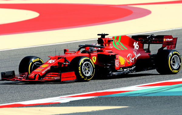 Красный гоночный автомобиль Ferrari SF21 2021 года на трассе