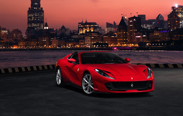 Красный автомобиль Ferrari 812 GTS  на фоне ночного города
