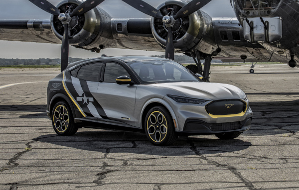 Серебристый Ford Mustang Mach-E, 2021 года у самолета