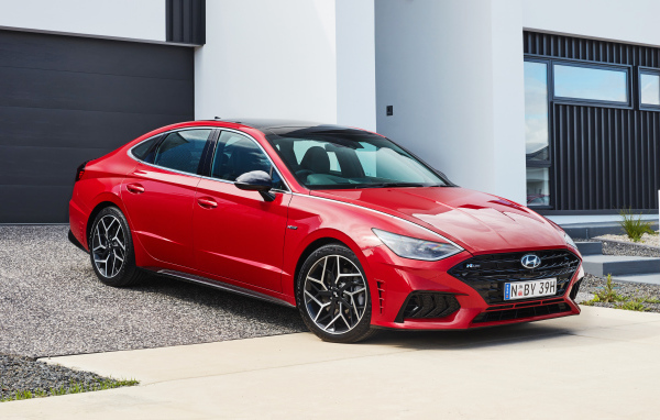 Красный автомобиль Hyundai Sonata N Line 2021 года у гаража