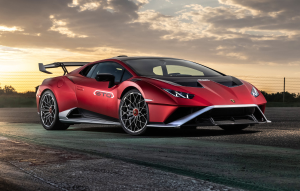 Красный автомобиль Lamborghini Huracán STO 2021 года на фоне неба