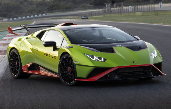 Зеленый автомобиль Lamborghini Huracán STO 2021 года на дороге