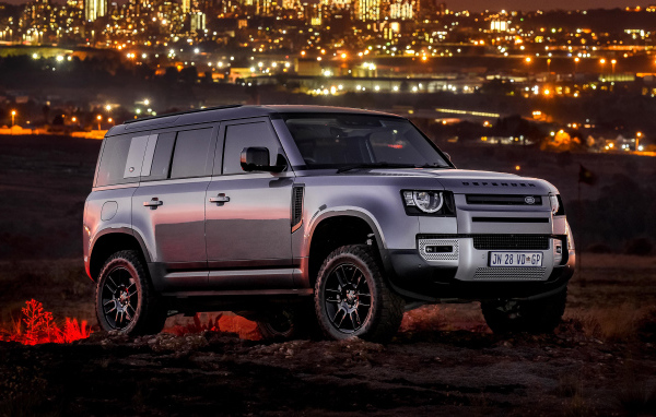 Серебристый внедорожник Land Rover Defender 110 P400 S Urban Pack 2021 года на фоне города