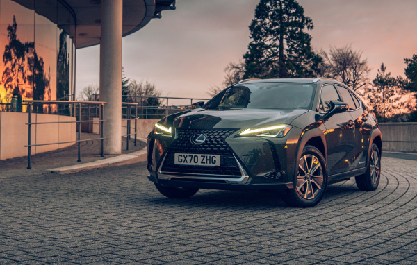 Автомобиль Lexus UX 300e 2021 года с включенными фарами