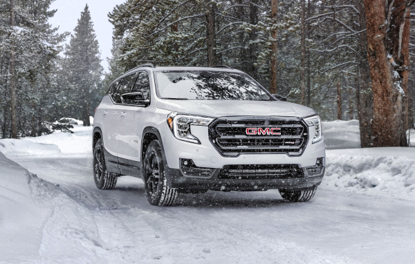 Большой белый внедорожник GMC Terrain AT4, 2022 года на снегу