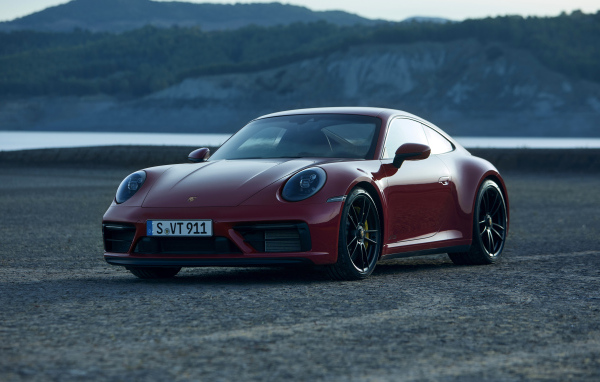 Красный Porsche 911 Carrera GTS 2021 года на фоне гор