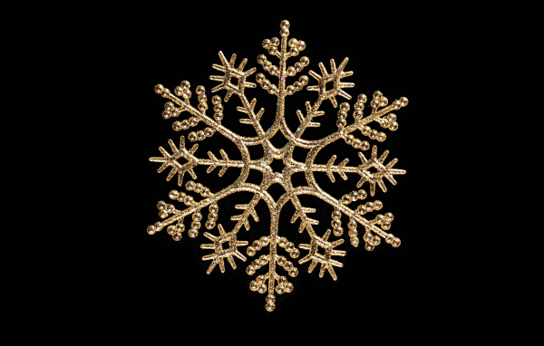 Красивая золотистая снежинка на черном фоне