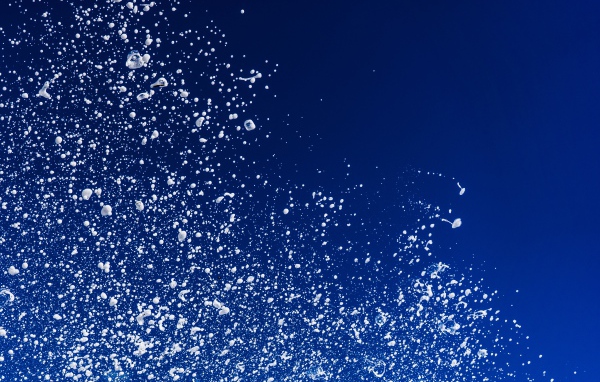 Белые брызги воды на синем фоне 