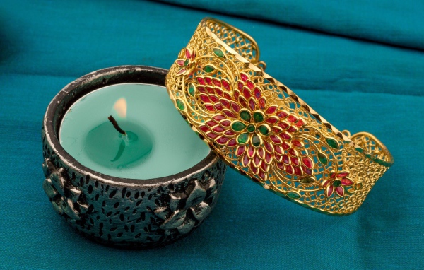 Красивый браслет со свечой на синем покрывале 