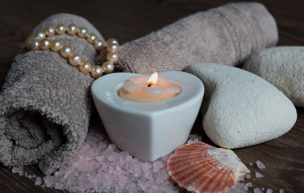 Красивая свеча с полотенцем, бусами, камнями и морской солью
