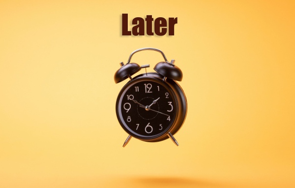 Большой черный будильник на желтом фоне 