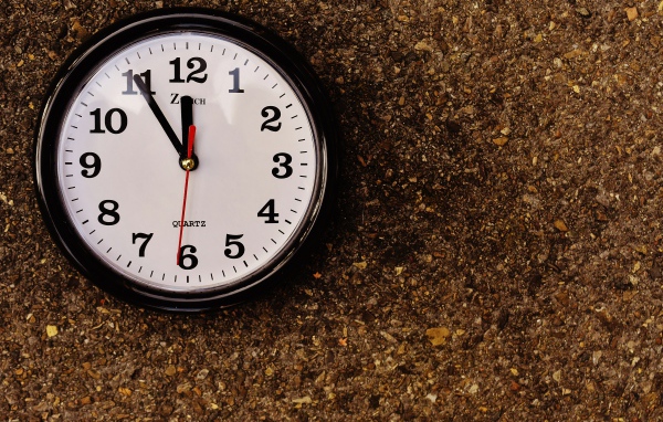 Большие черные часы висят на стене 