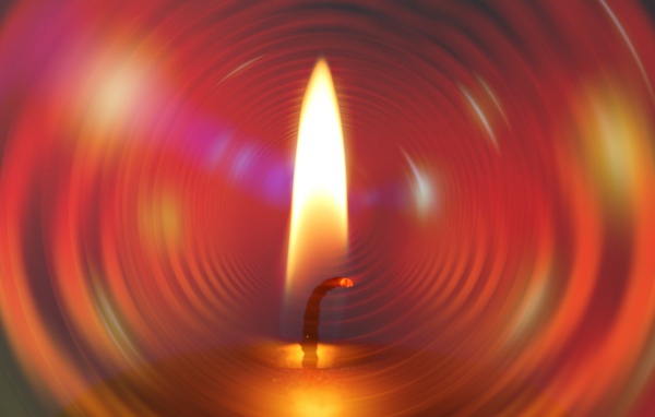 Огонь свечи на фоне красного круга 