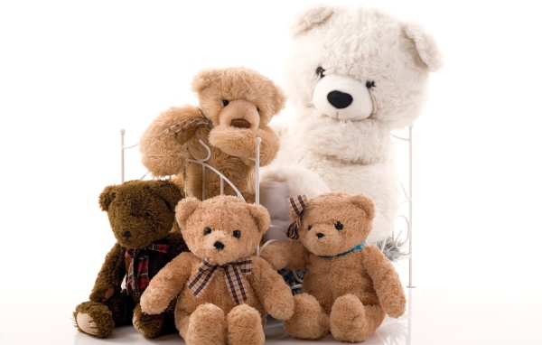 Много игрушечных медведей на детской кровати