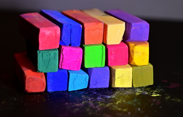 Разноцветные мелки для школы на черной поверхности 