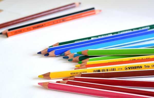 Разноцветные карандаши на белом столе 