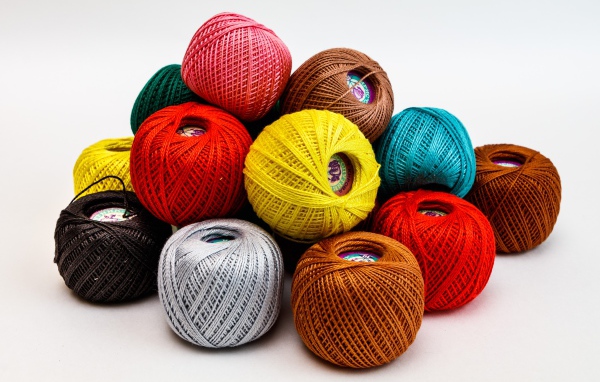 Разноцветные клубки пряжи на белом фоне 