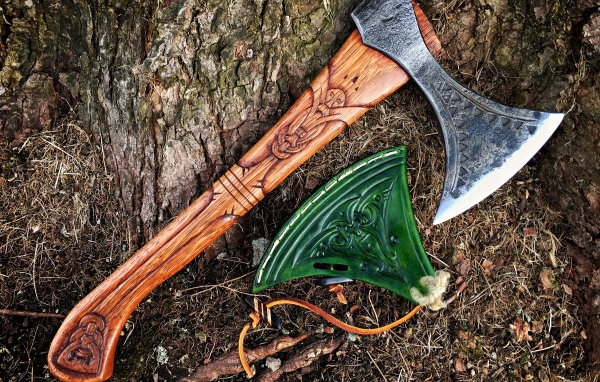 Старый топор с рисунком у дерева 