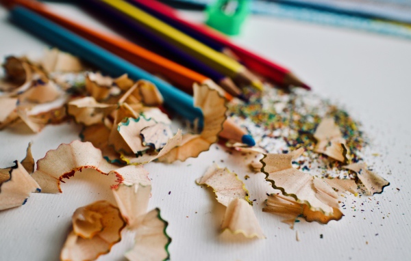 Карандаши со стружкой на сером столе 