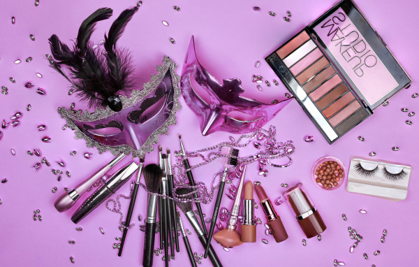 Набор косметики с масками на сиреневом фоне 