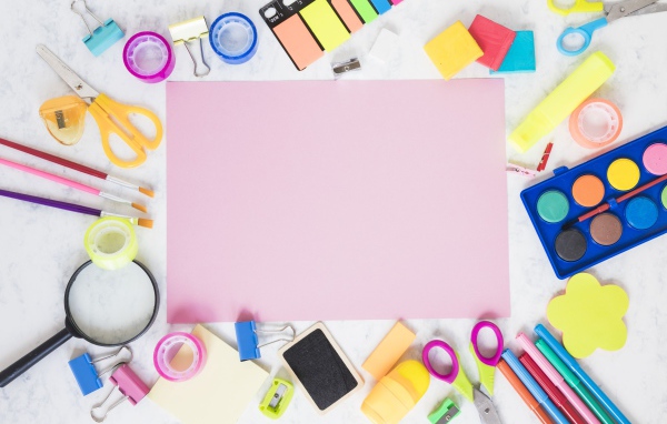Лист бумаги, краски и канцелярские предметы на столе 